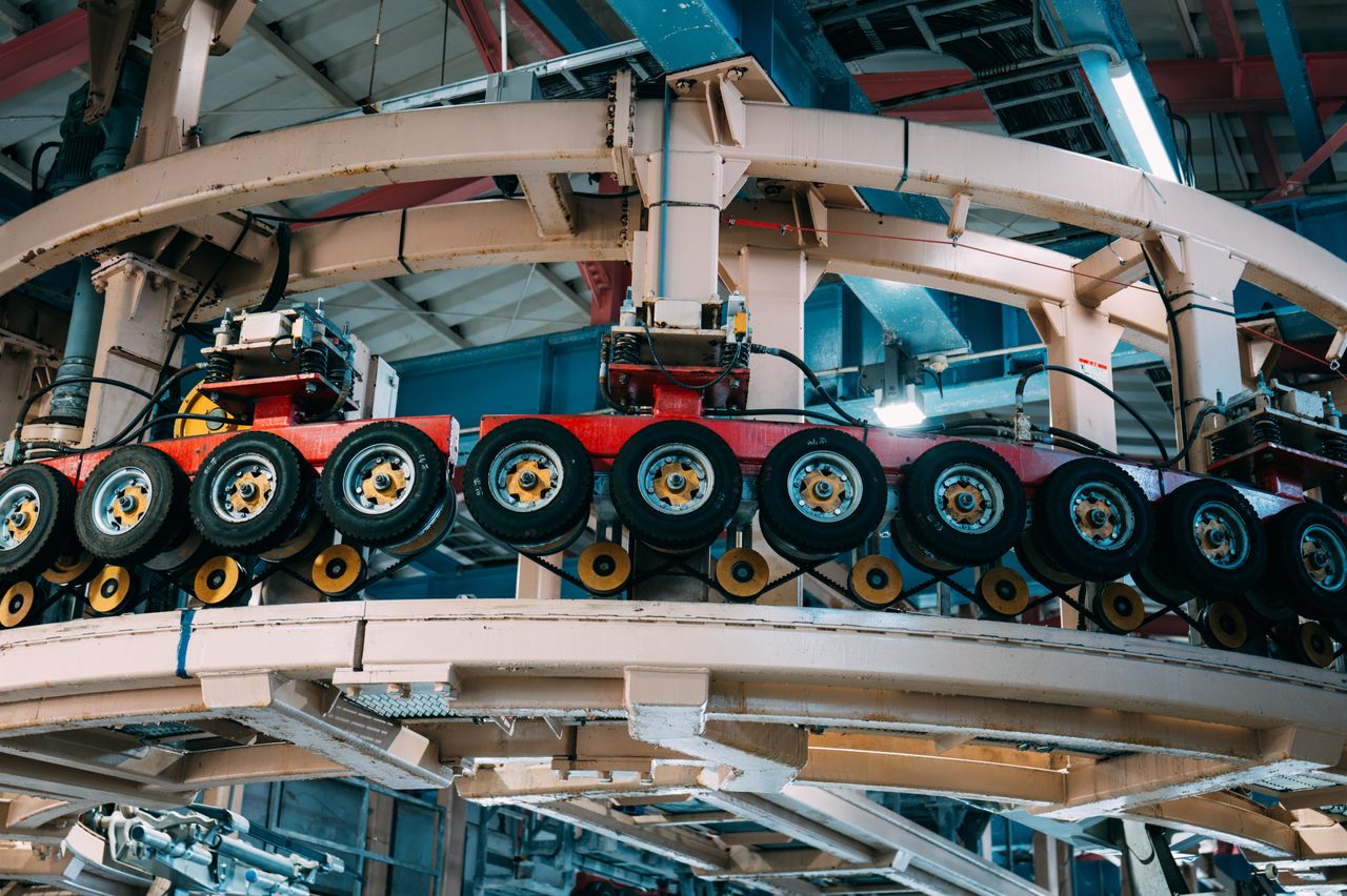 Home Close-up view of a complex industrial conveyor system inside a manufacturing facility.